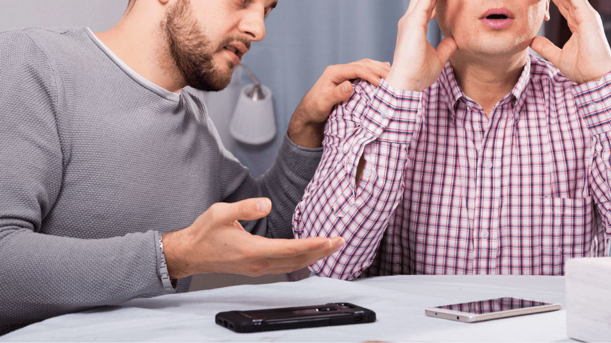 Two men having an argument at a table.
