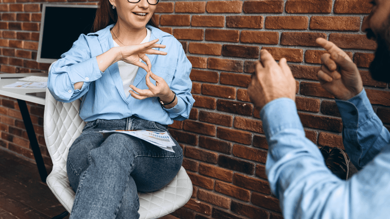 two people in classroom speaking in sign language