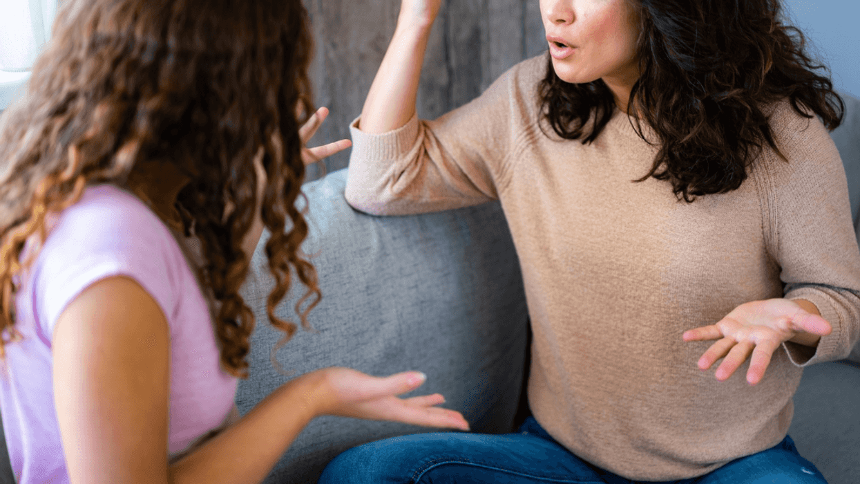 two wimen seated on a couch arguing