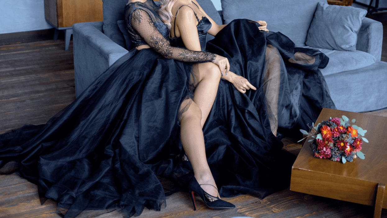 two women in black wedding dresses seated on a couch