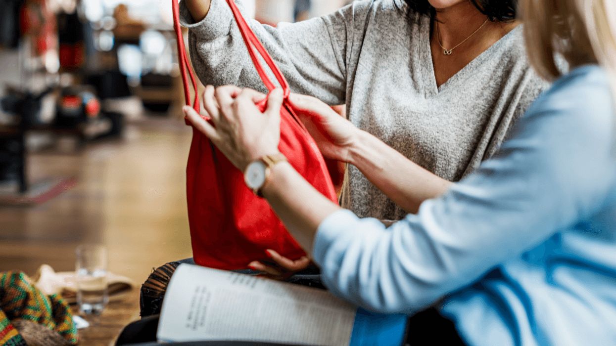 two women looking at a purse