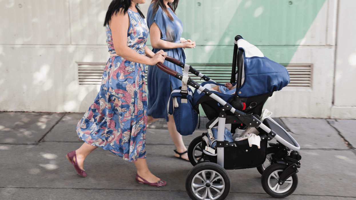 Two women pushing a baby carriage