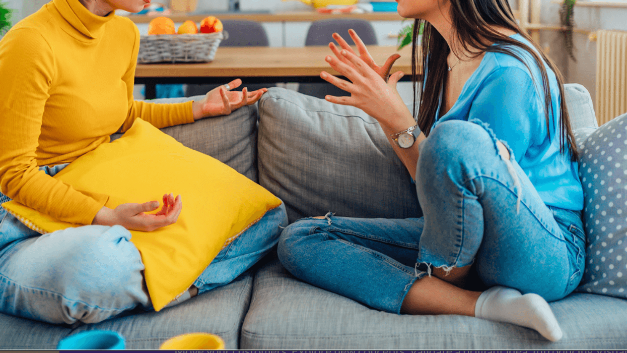 Two women sitting on the couch having an argument.
