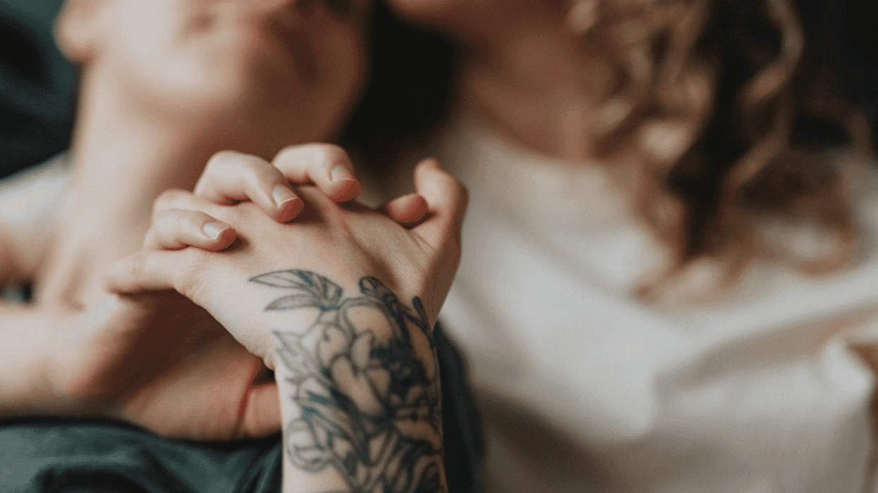 Two women snuggling and holding hands.