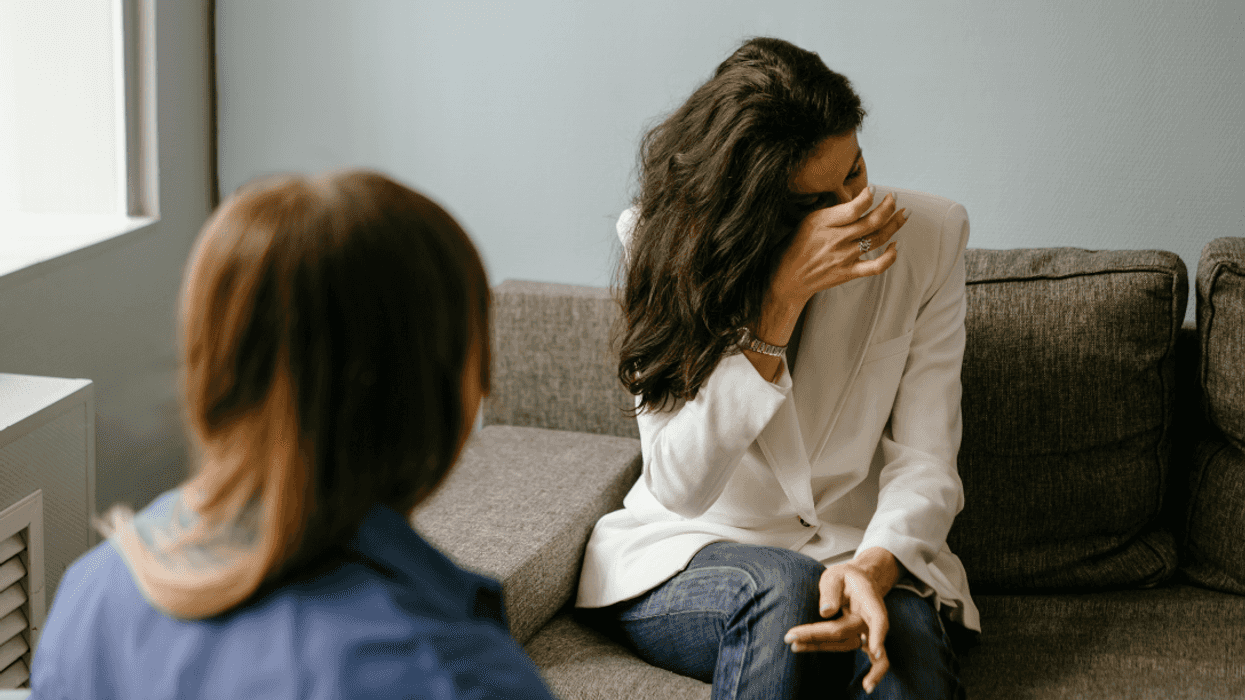 two women with one wiping away tears