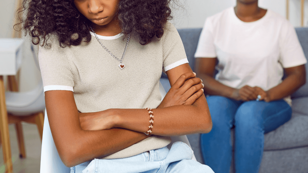 unhappy teen girl with mother in background