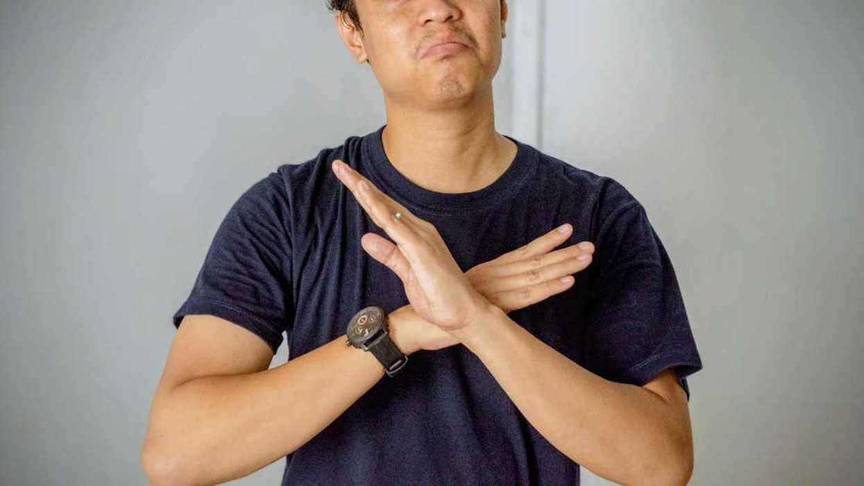 unhappy young man with hands crossed in front of him