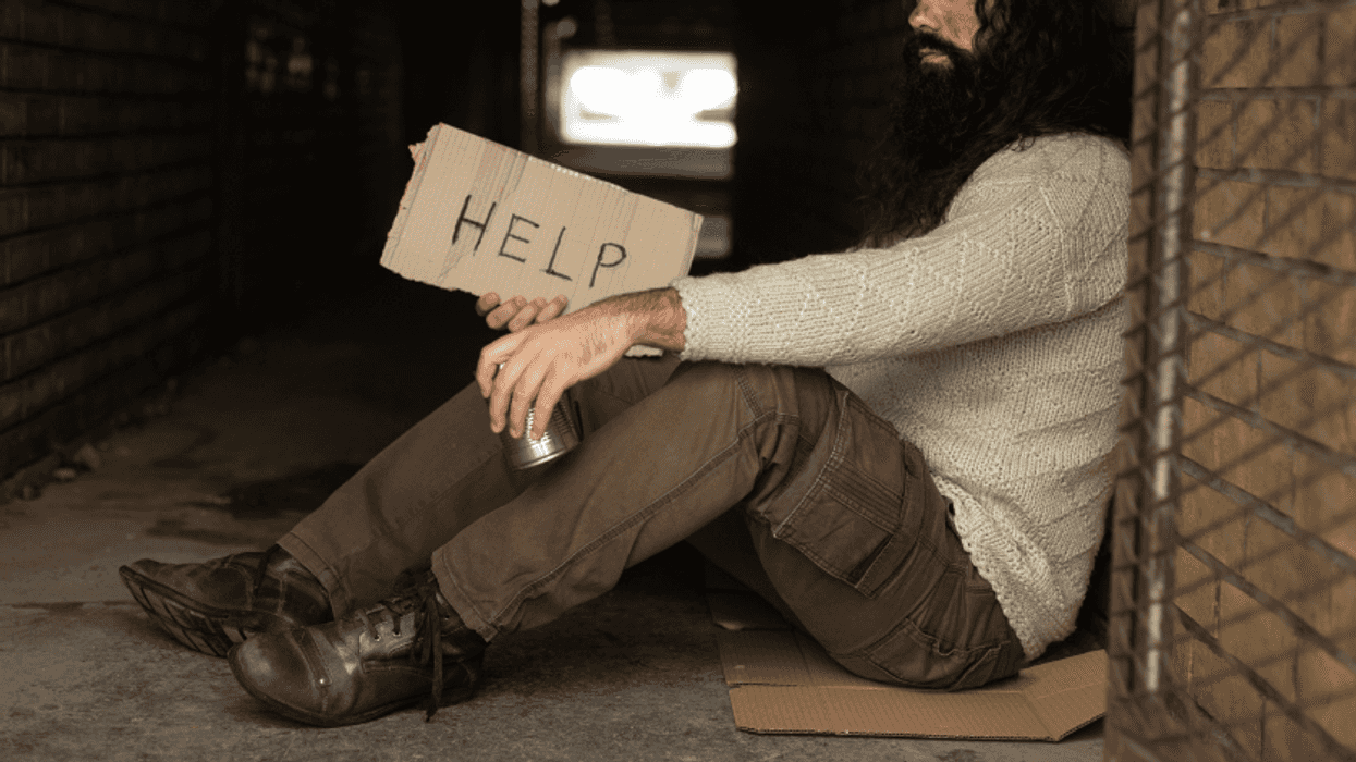 unhoused man in tunnel entrance