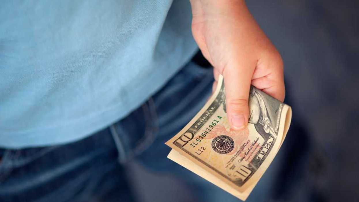 Unidentified young boy holds ten dollars.