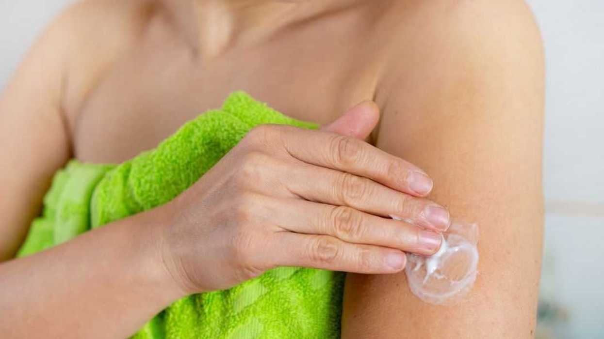 Unknown woman applying progesterone cream onto her arm.