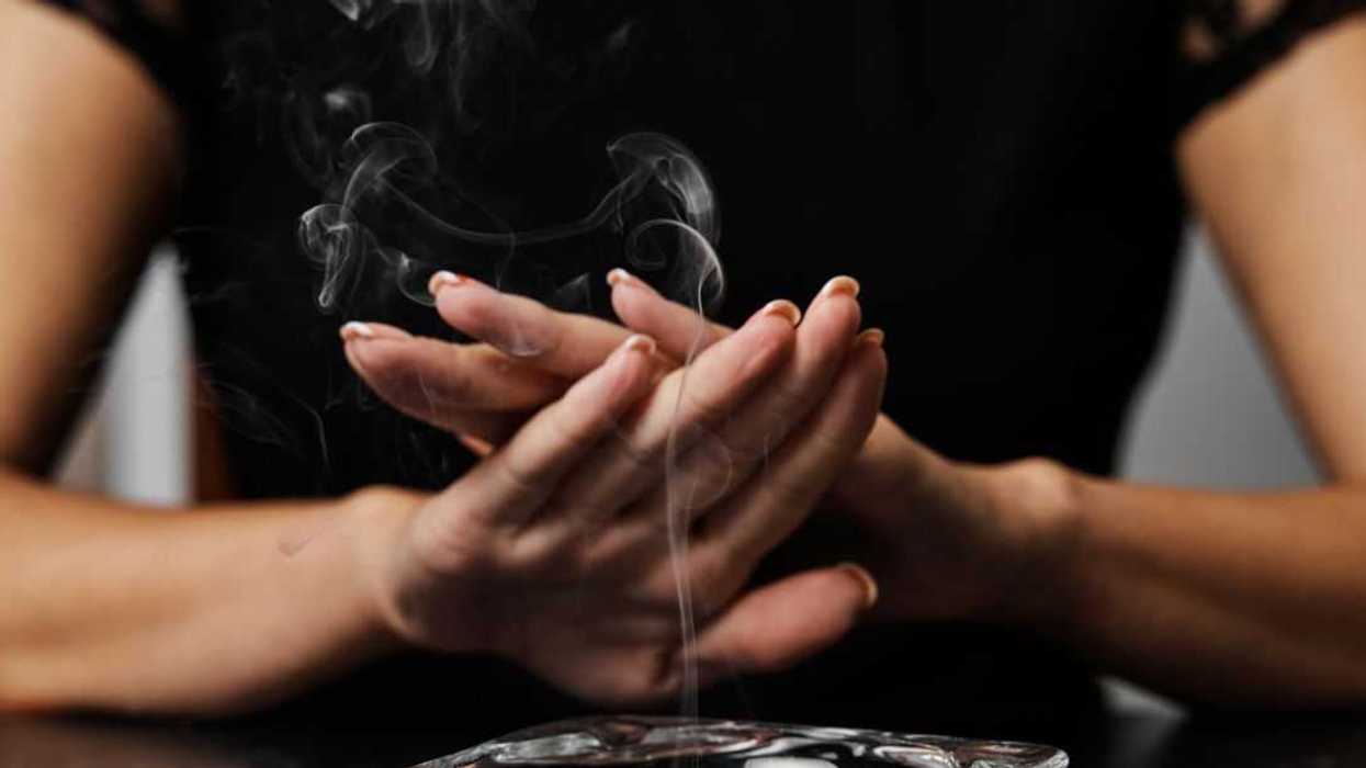 Unrecognizable young woman refusing smoking with an ashtray full of cigarette butts in front of her.