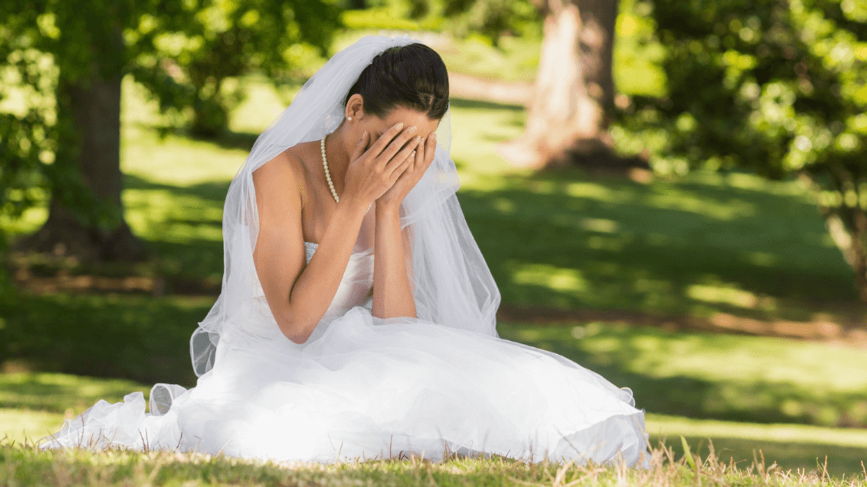 upset bride seated on the grass