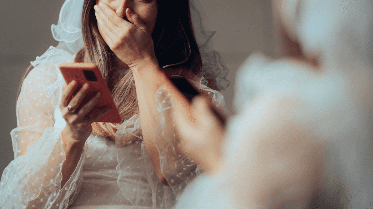 upset bride with phone in front of mirror