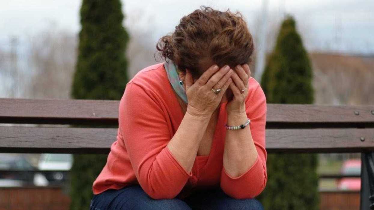 upset older woman on park bench
