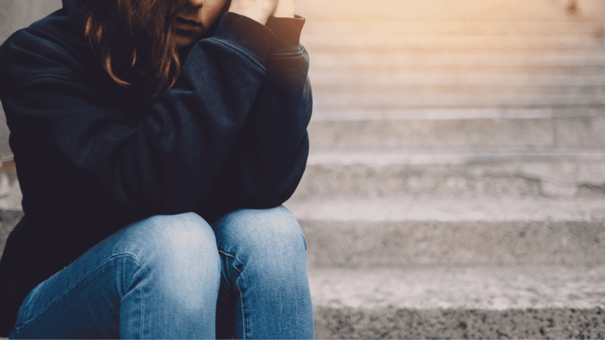 Upset teenager sitting on stairs