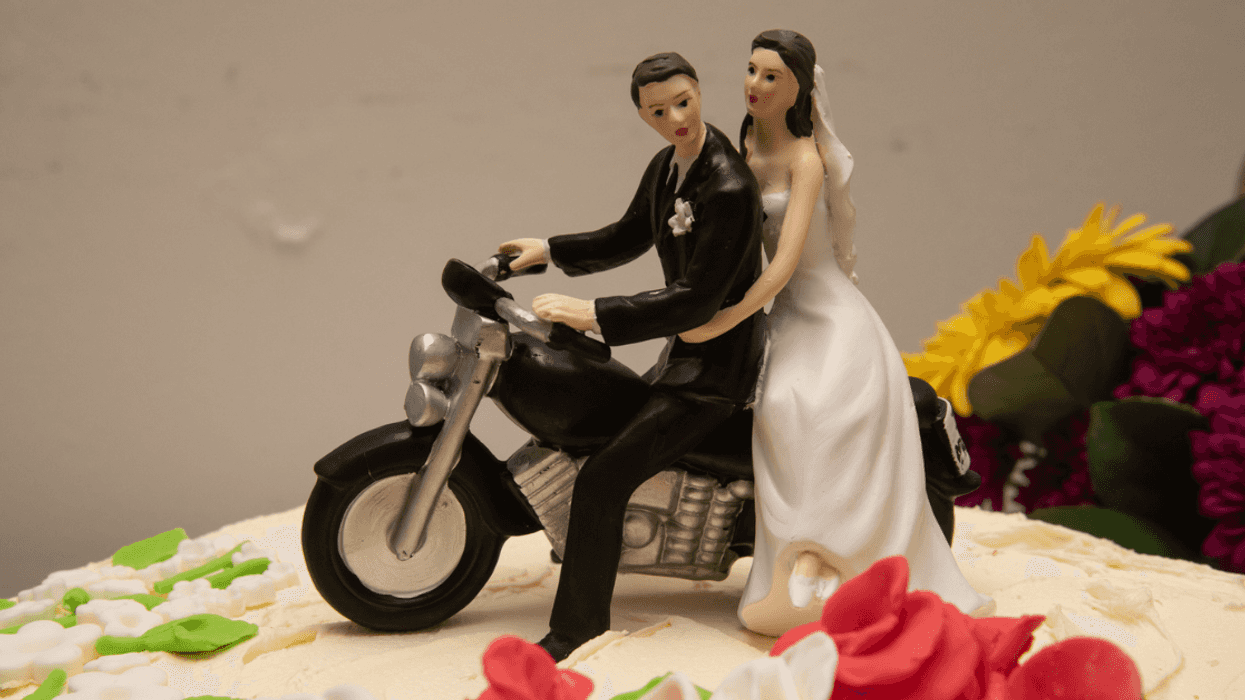 wedding cake topper with bride and groom on motorcycle