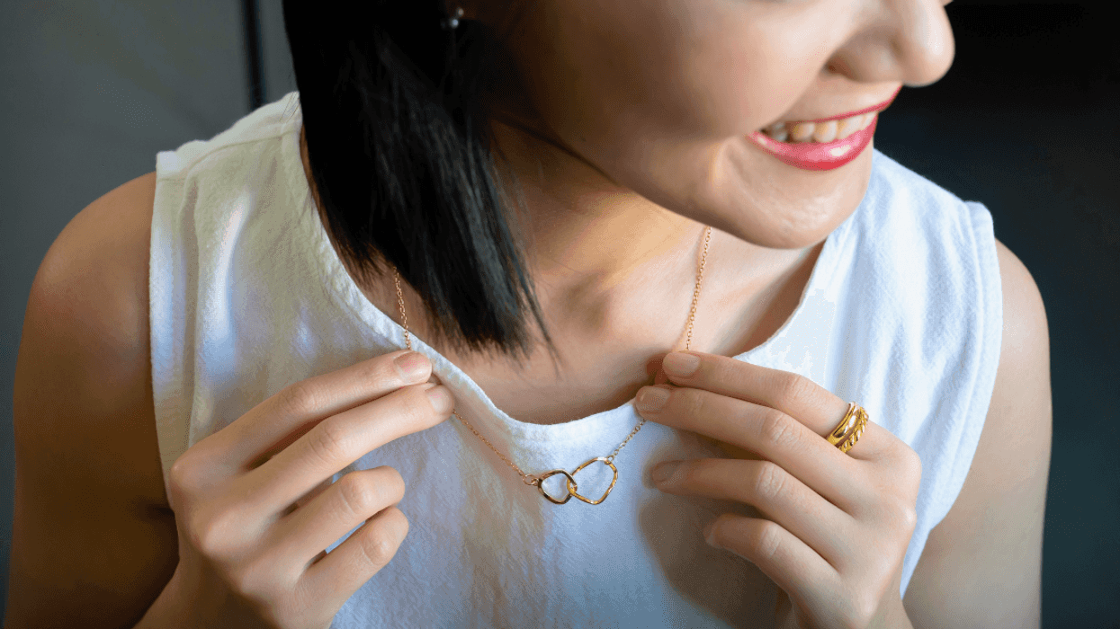 woman adjusting gold necklace