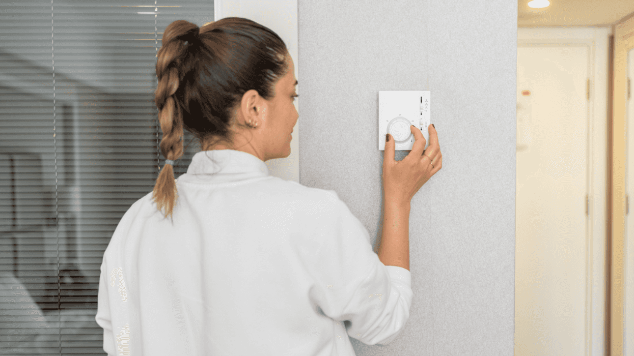 Woman adjusting thermostat