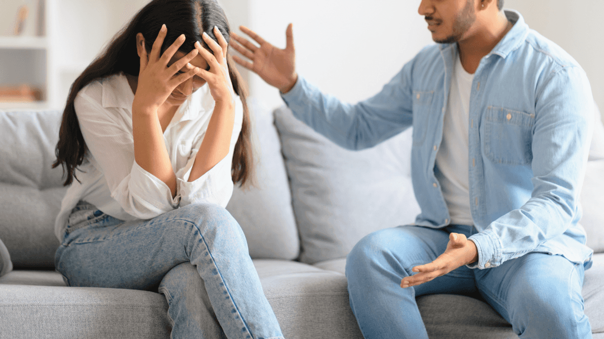 woman and man seated on couch arguing