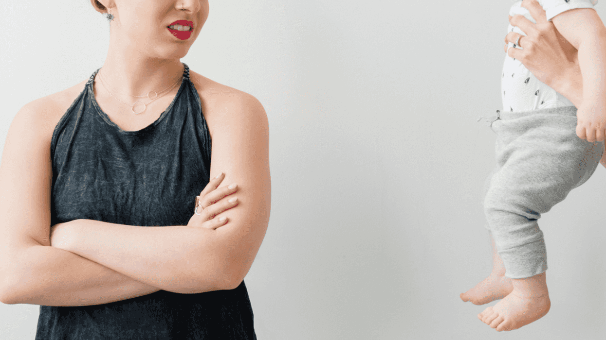 Woman appearing disgusted when asked to hold a baby