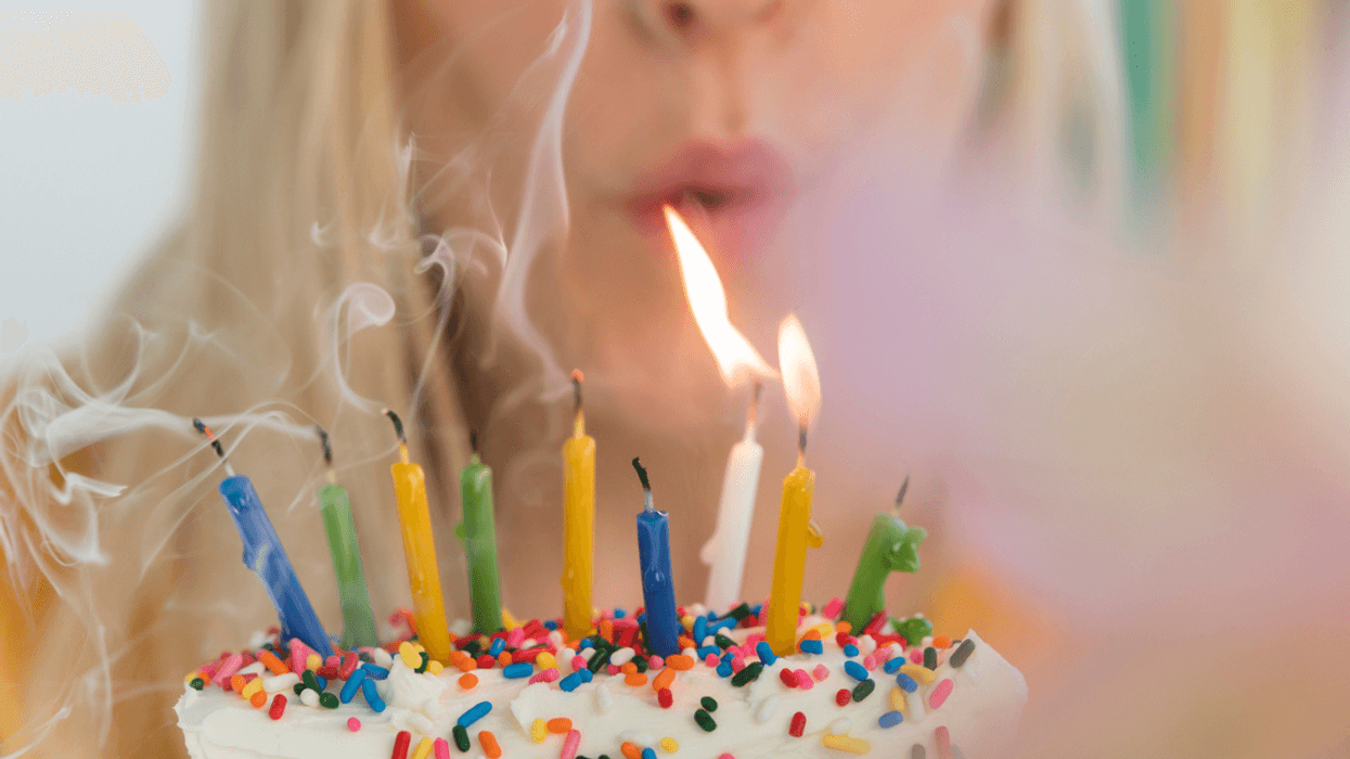 Woman blowing out birthday candles.