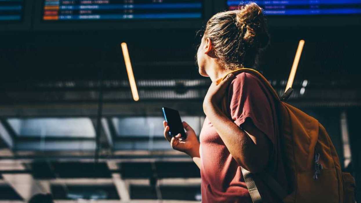 Woman checks airline schedule at airport.