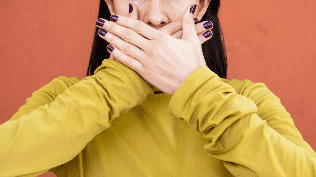 Woman covering her mouth to stop talking