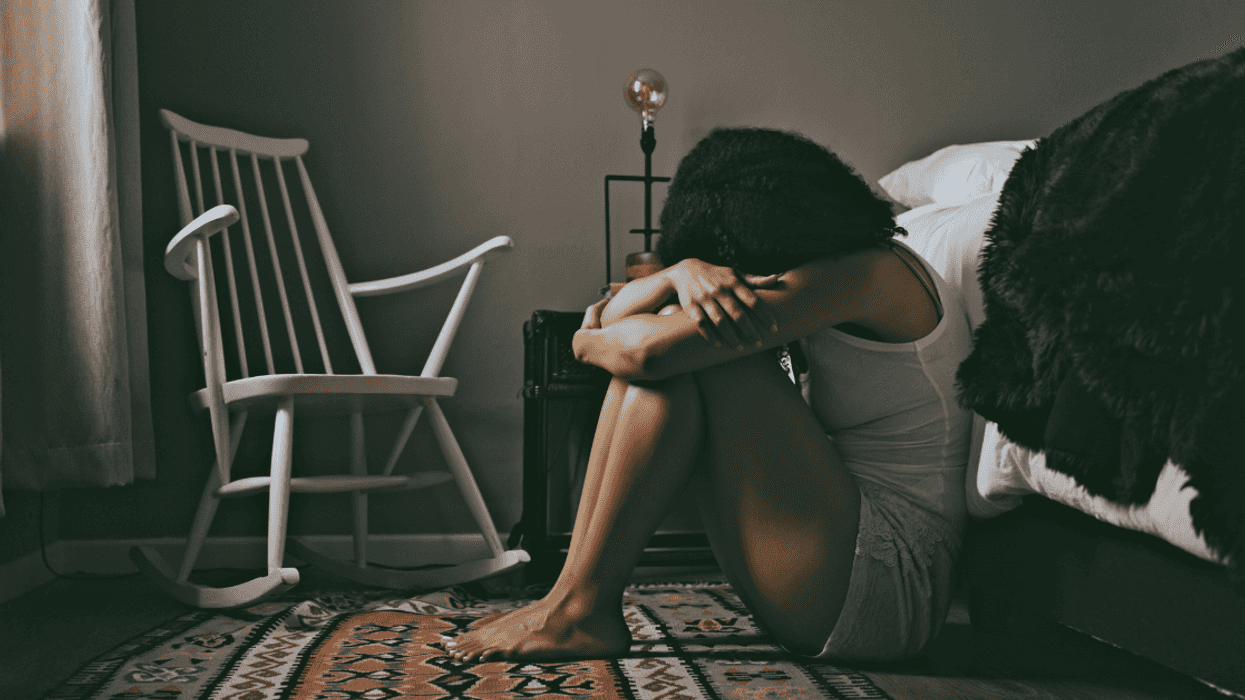 Woman crying on bedroom floor