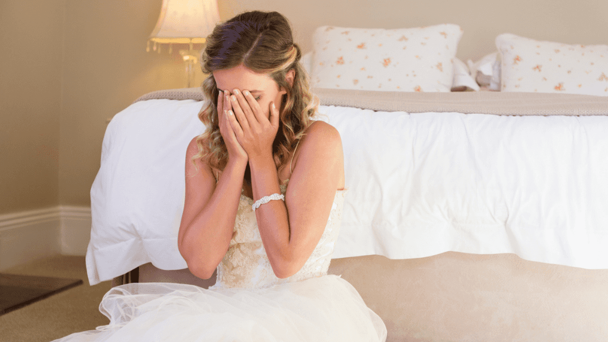Woman crying while wearing wedding dress