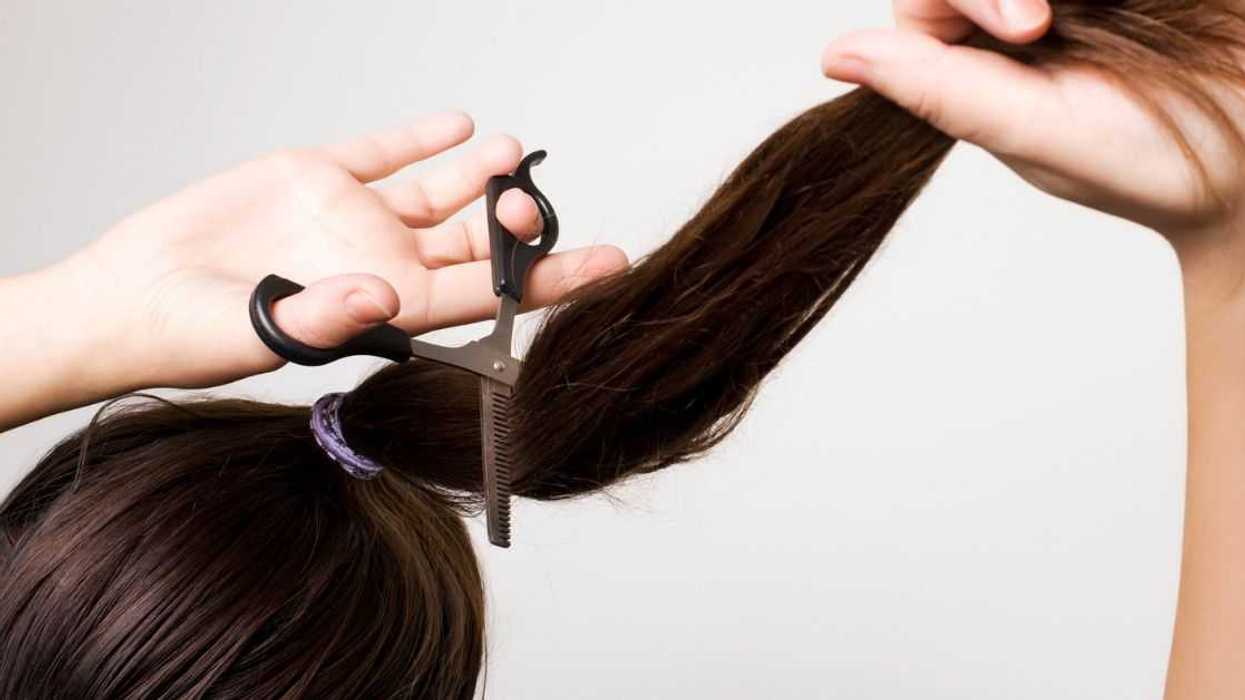 Woman cutting her ponytail.