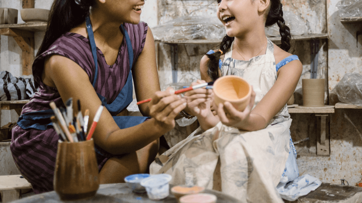 Woman doing art with young girl