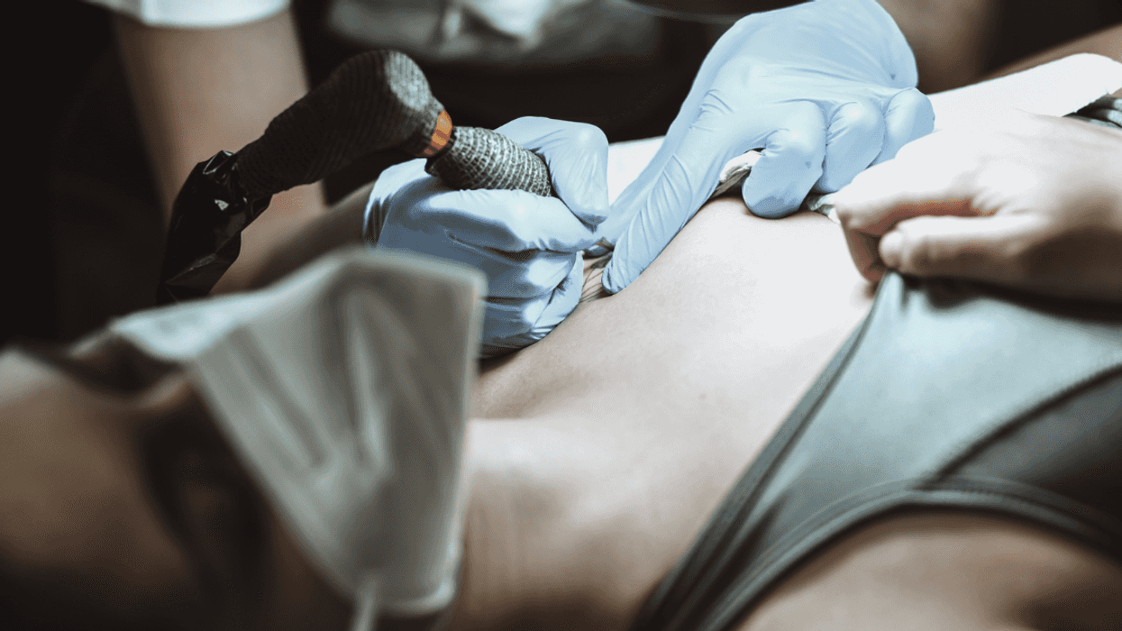woman getting tattoo on her chest