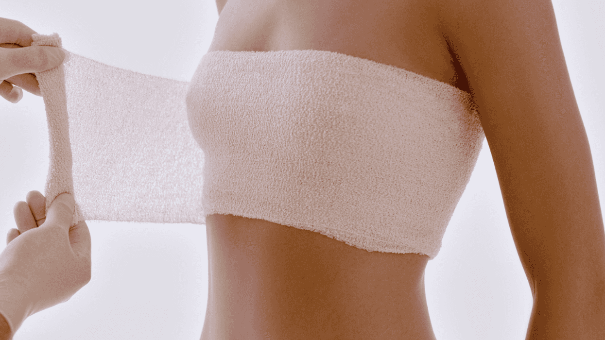 woman having breasts wrapped after cosmetic procedure