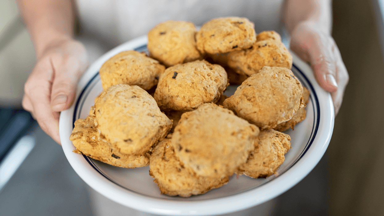 Woman holding a plate of baked goods.