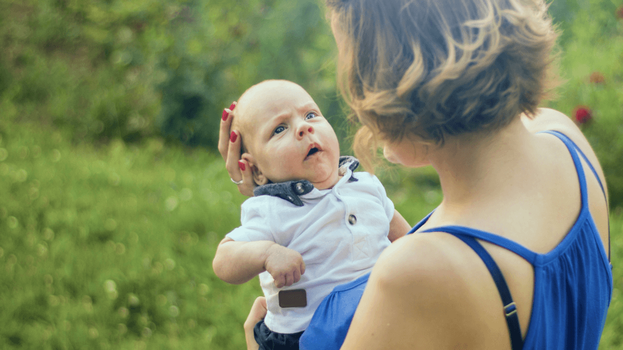Woman holding baby away from her
