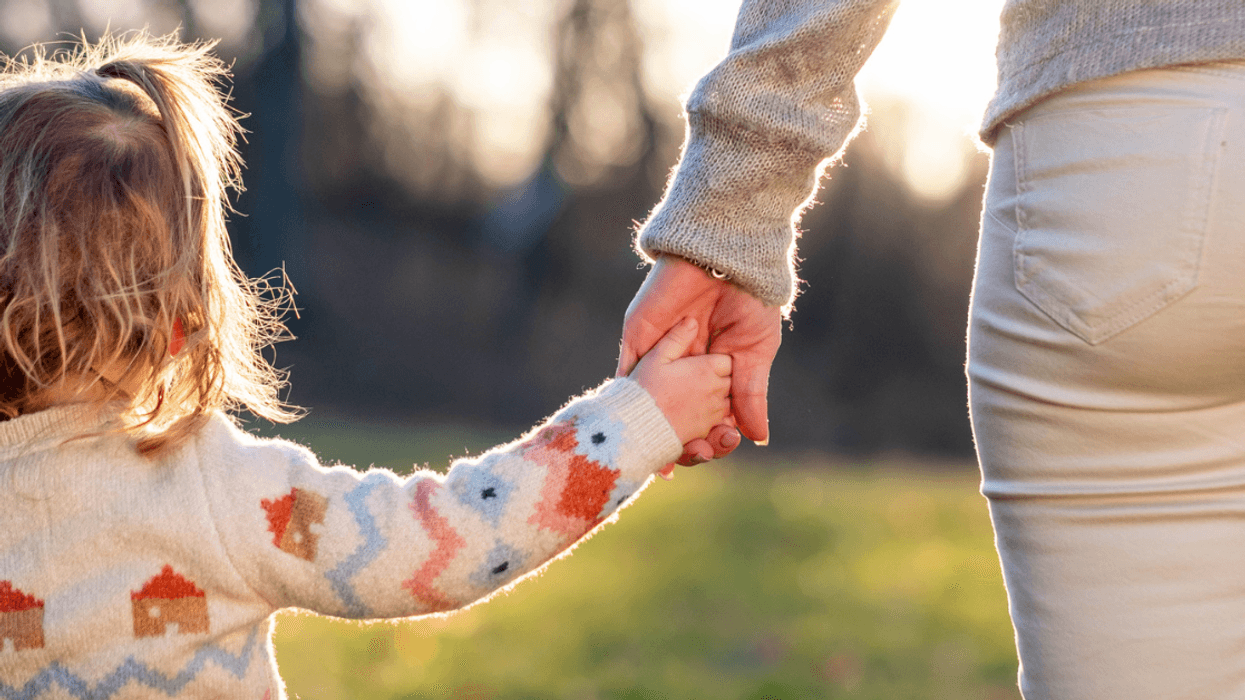Woman holding hands with her child