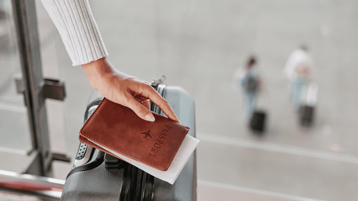 Woman holding passport and suitcase