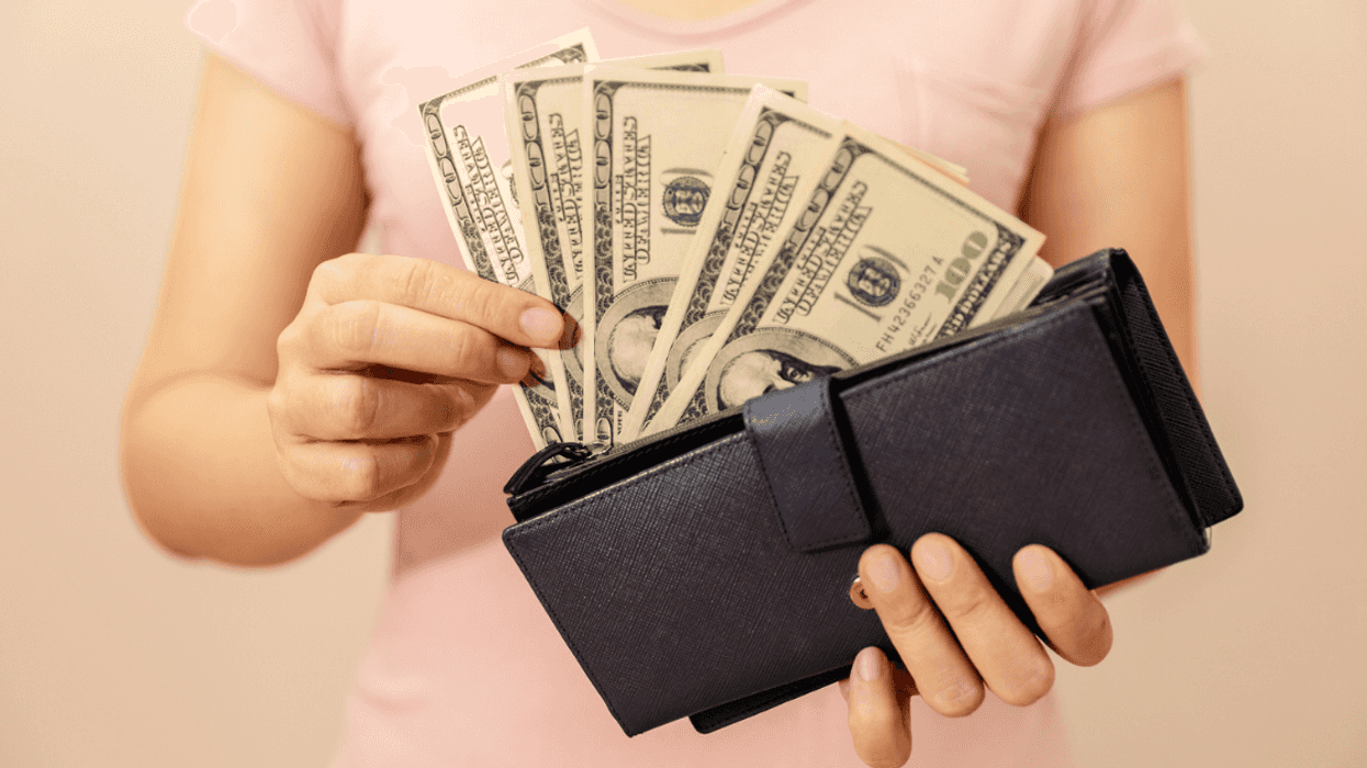Woman holding wallet full of cash