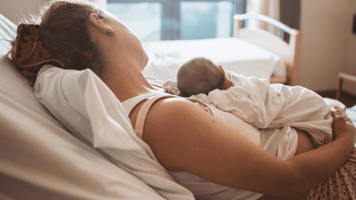 Woman in a hospital bed holding a baby.