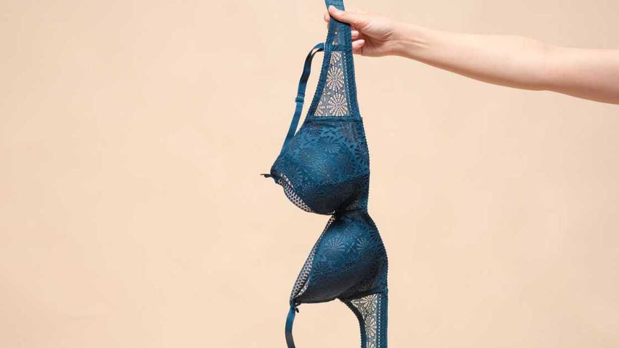 Woman is showing a new bra in the hand.