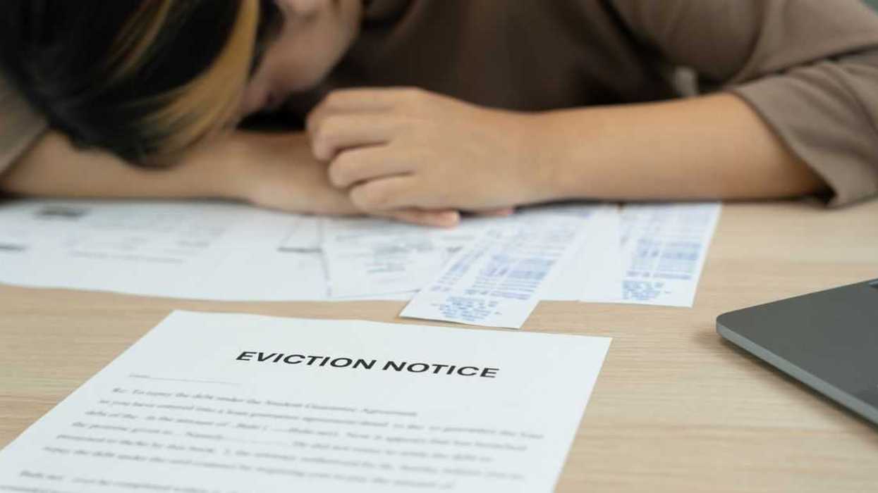 Woman is stressed due to imminent seizure of assets, debts, financial problems, loans, guarantees document with the text eviction notice, debt, property, loan, agent, bankruptcy.