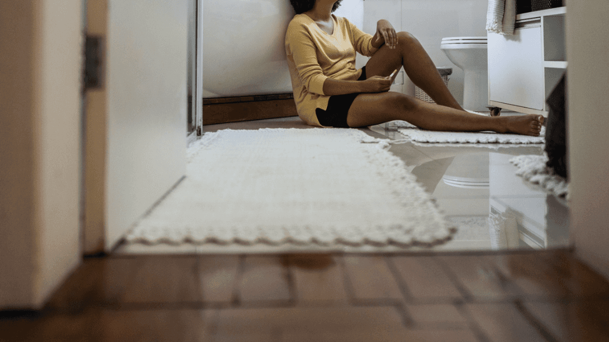 Woman leaning against a bathtub.