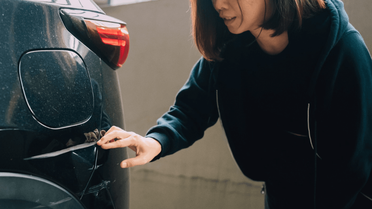 Woman looking at car damage