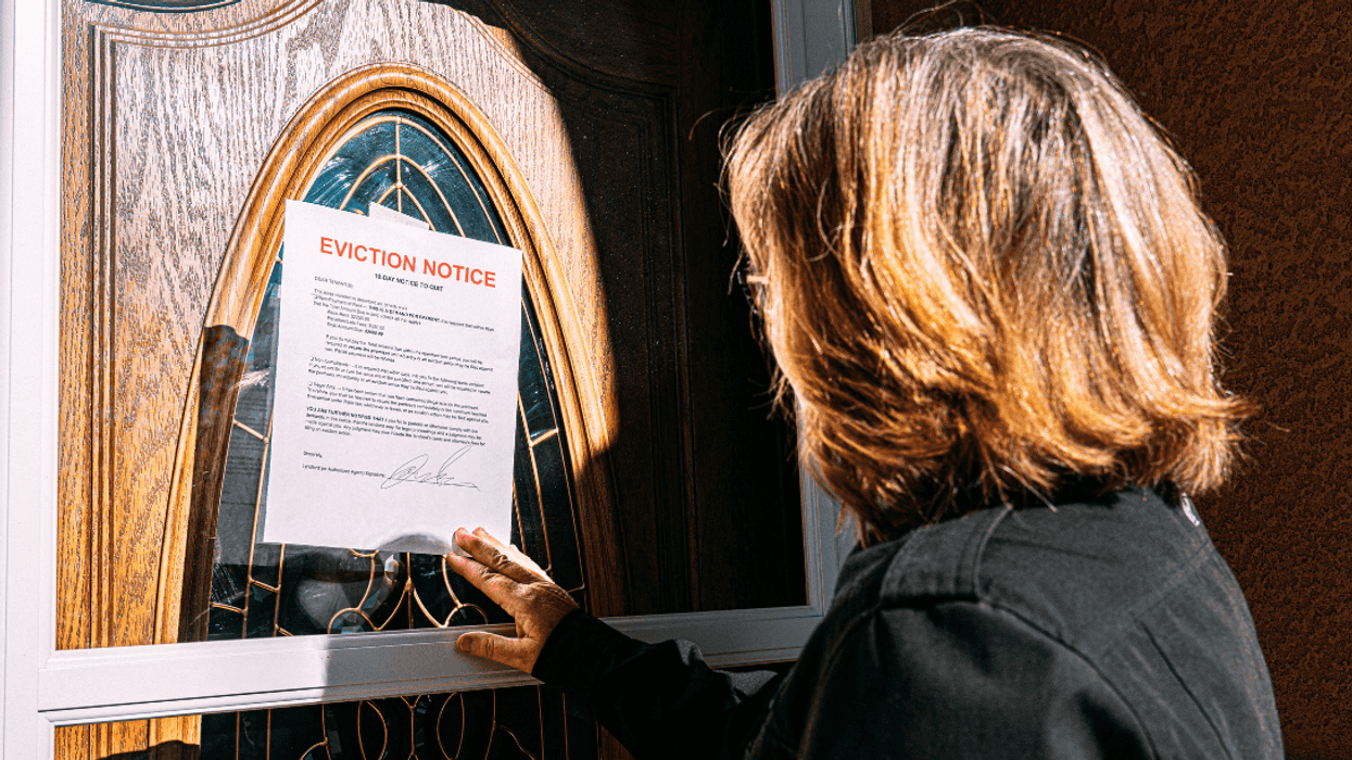 woman looking at eviction notice on door