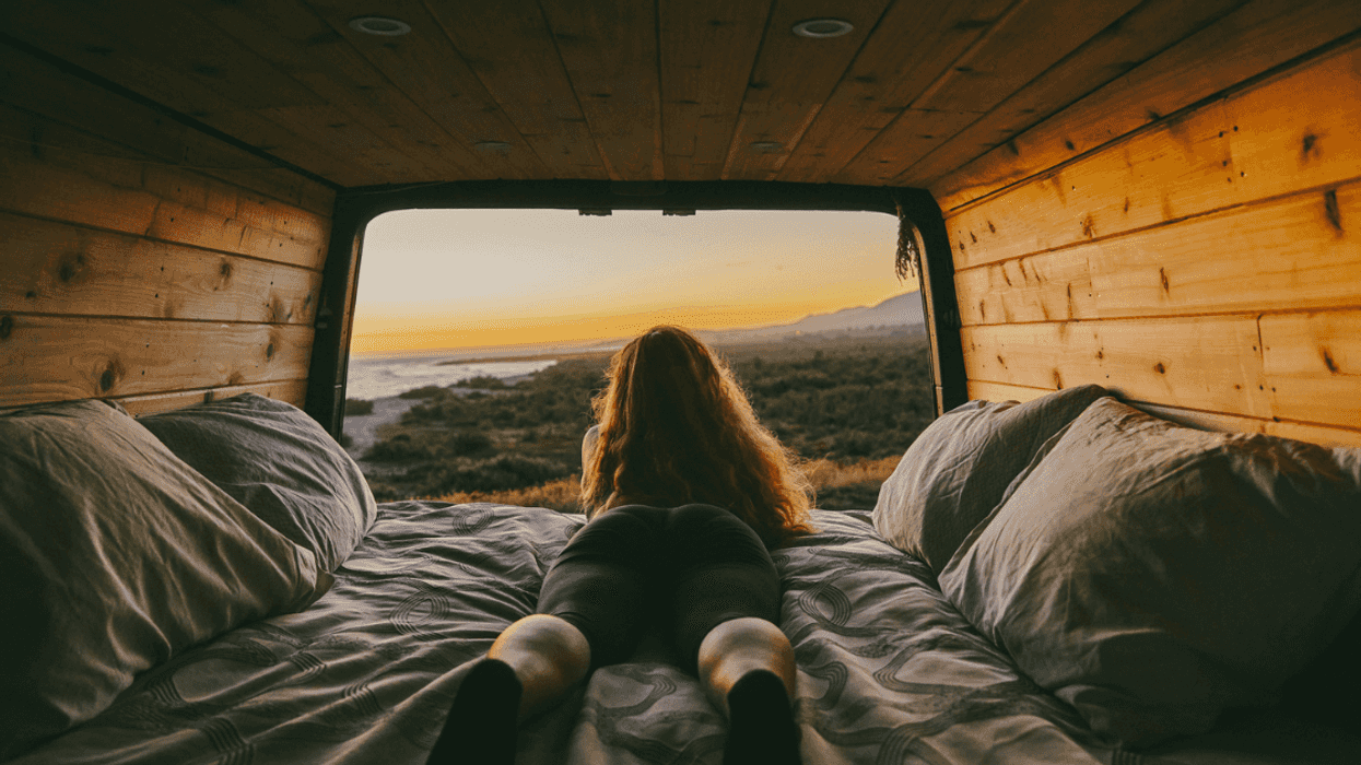 Woman looking out of the window of camper van.