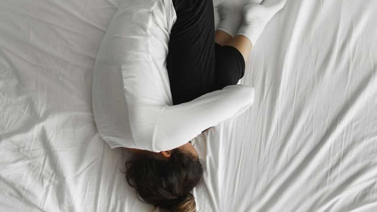 Woman lying on bed with face closed.