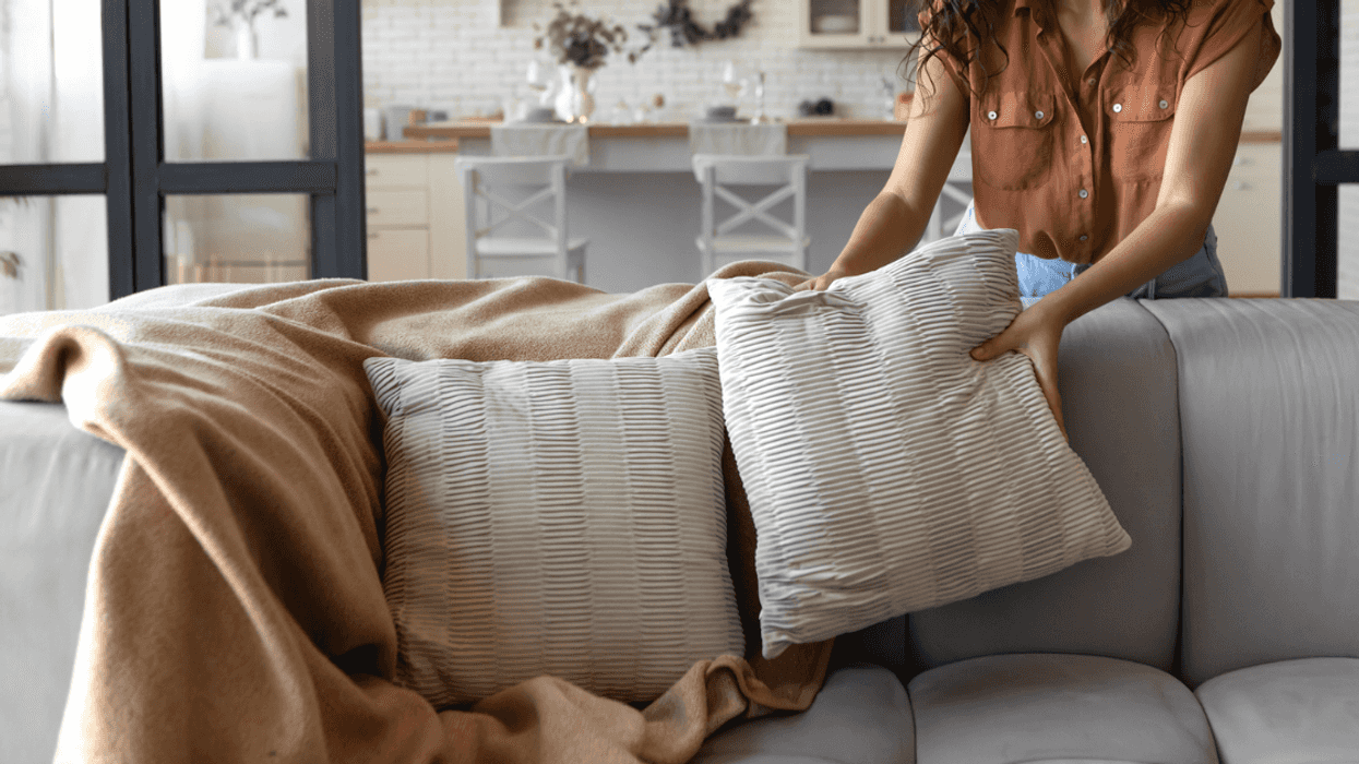 woman placing pillows on sofa