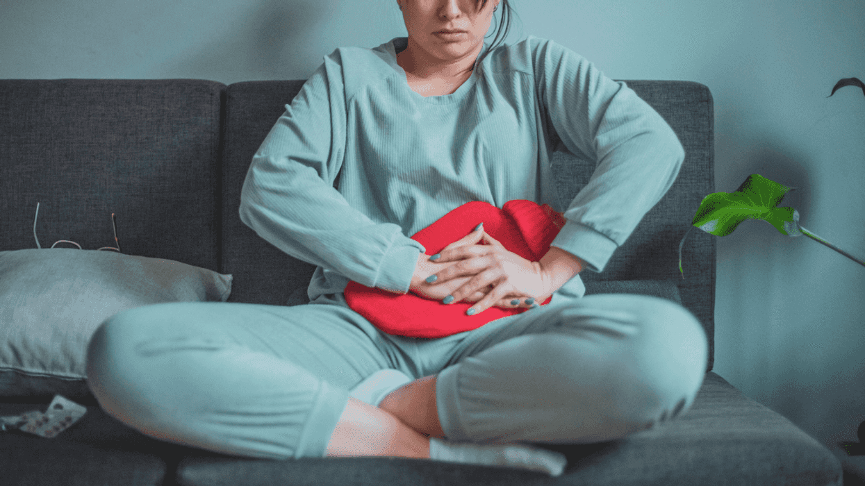 Woman pressing a hot pad to her stomach