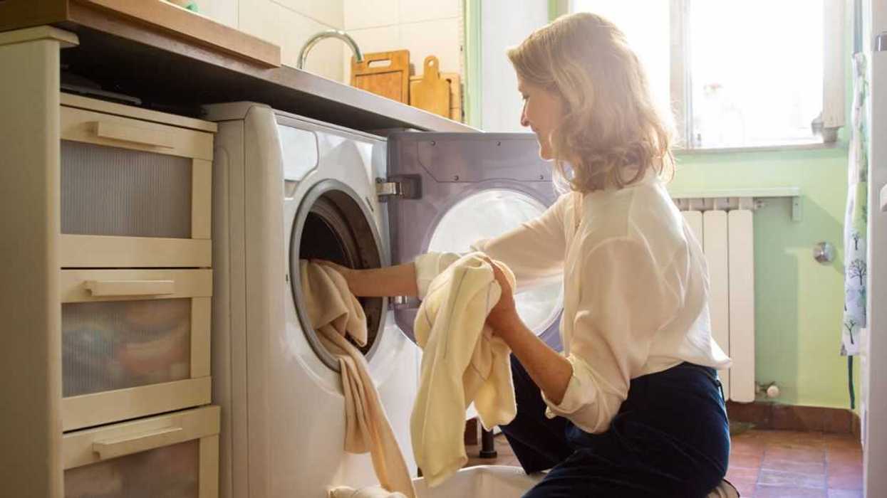 Woman putting cashmere sweaters in the washing machine