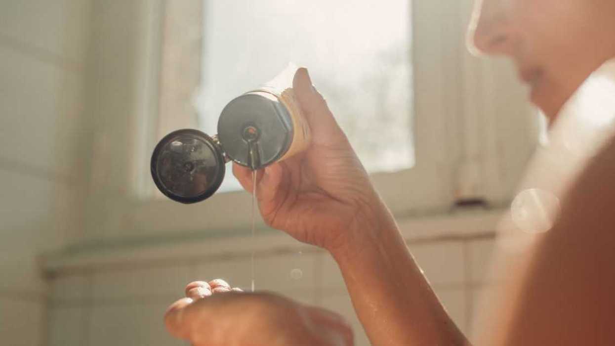 Woman putting hair shampoo on her hand , ready for hair washing.